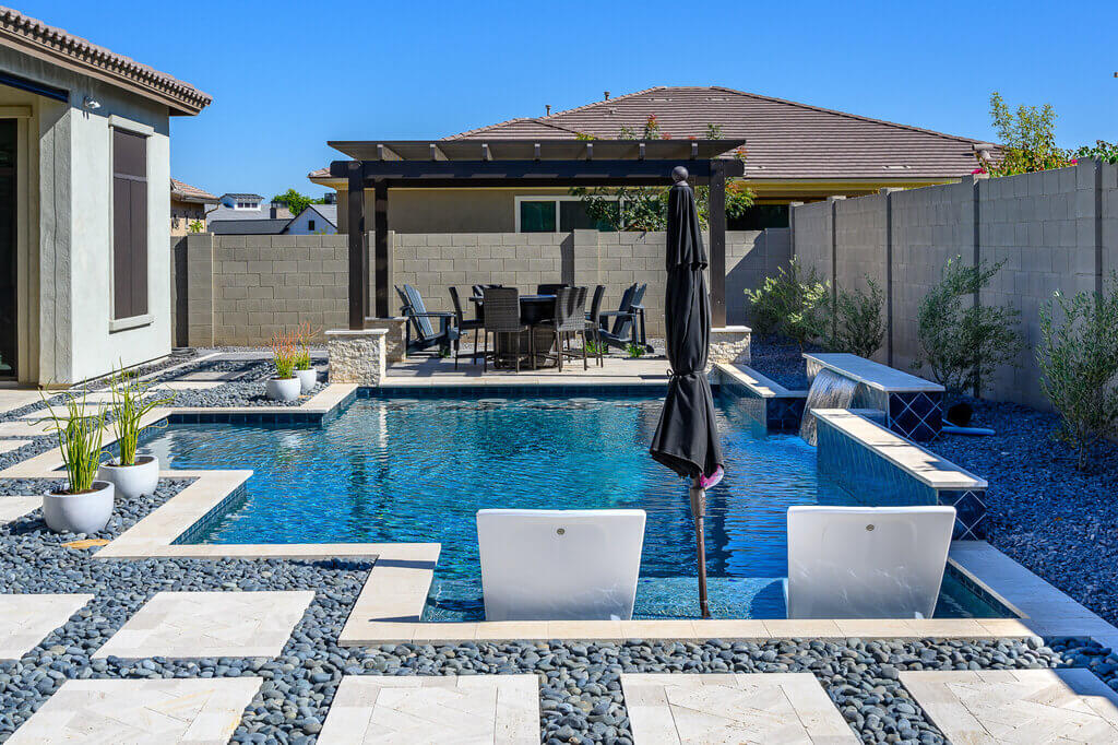 A backyard with a pool and patio furniture