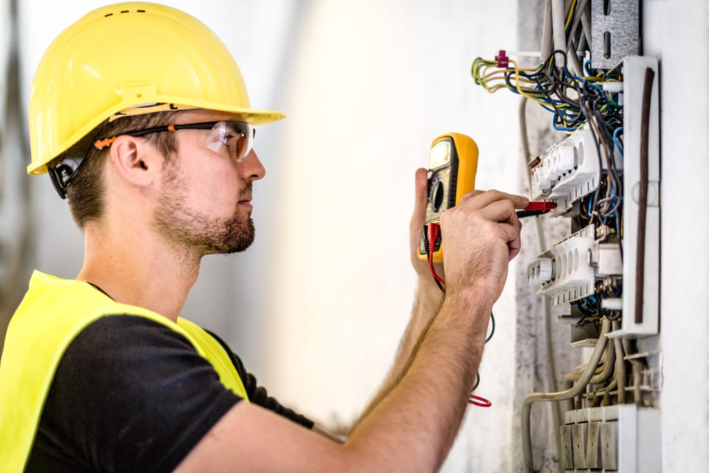 A man is working on an electrical panel