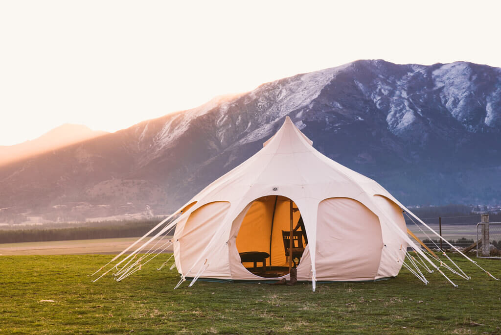 A white tent on top of a lush green field
