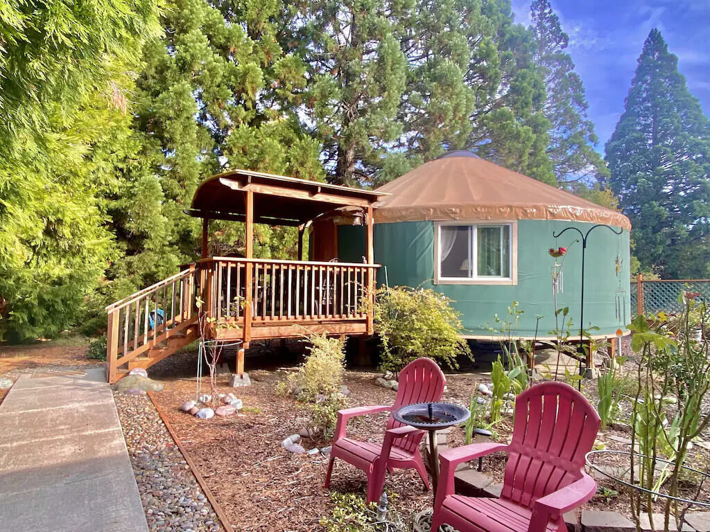 A couple of red chairs in front of a Yurt house
