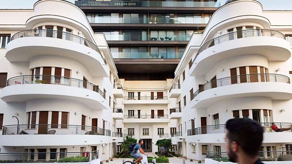 A man riding a skateboard past a tall building
