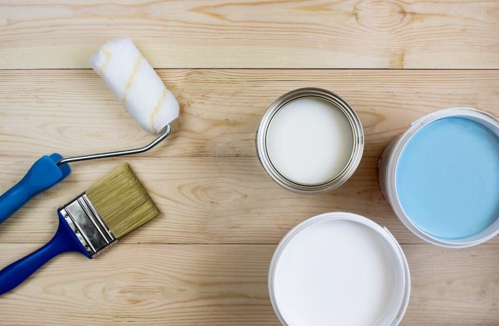 A wooden floor with fresh paint and a brush

